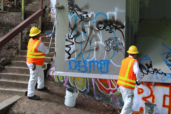 Photo of Graffiti Rangers painting a concrete wall
