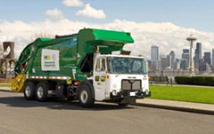 Parked garbage truck with the Seattle skyline in the background