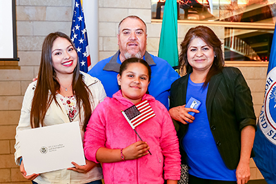 A family of new Americans at a citizenship ceremony in a brightly lit room in Seattle City Hall.