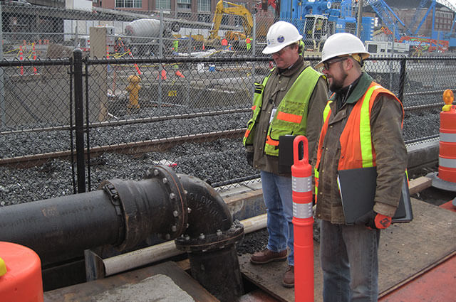 Two SPU employees inspecting a new pipeline during Alaskan Way Viaduct demolition.