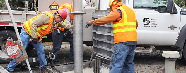 Photo of a utility crew cleaning a sewer pipe