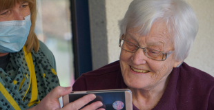 Senior woman smiling while looking at a phone
