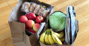 Two paper bags of groceries containing fresh fruit and veggies