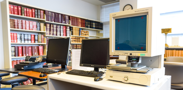 Research room with books, computer, and microfiche viewer