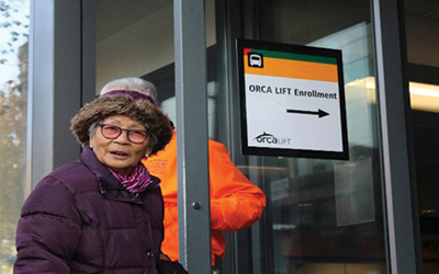 Woman signing up for an ORCA card.