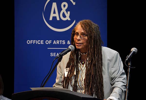 2019-21 Civic Poet Jourdan Imani Keith speaking at a podium in front of a Seattle Office of Arts & Culture banner.