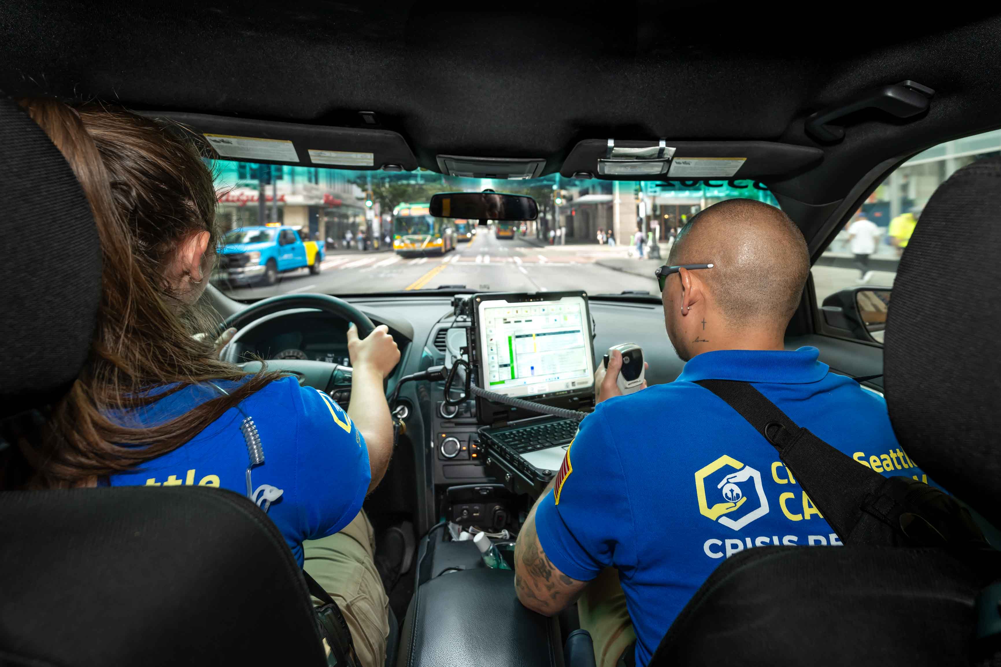 Two CARE community crisis responders driving on Third Avenue in crisis responder vehicle.