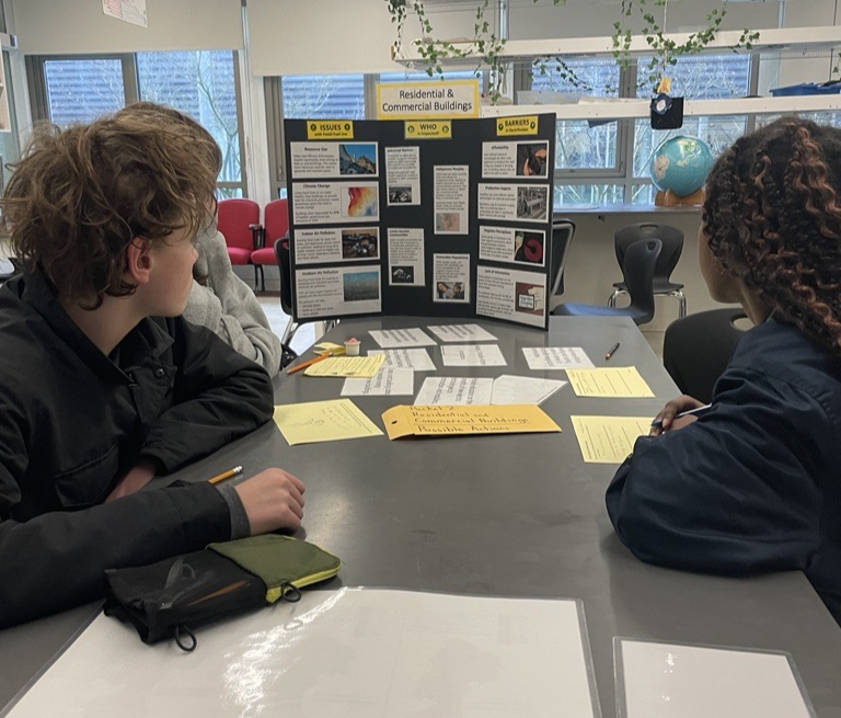 Two kids look at a climate information sheet