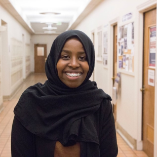 Ikhra Mohamed smiling in a hallway