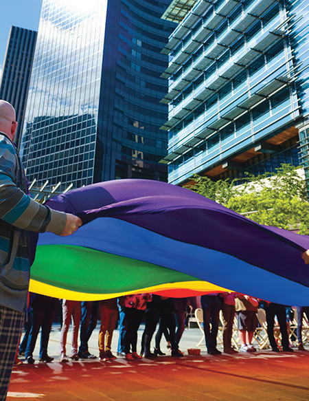 Workers holding large rainbow flag