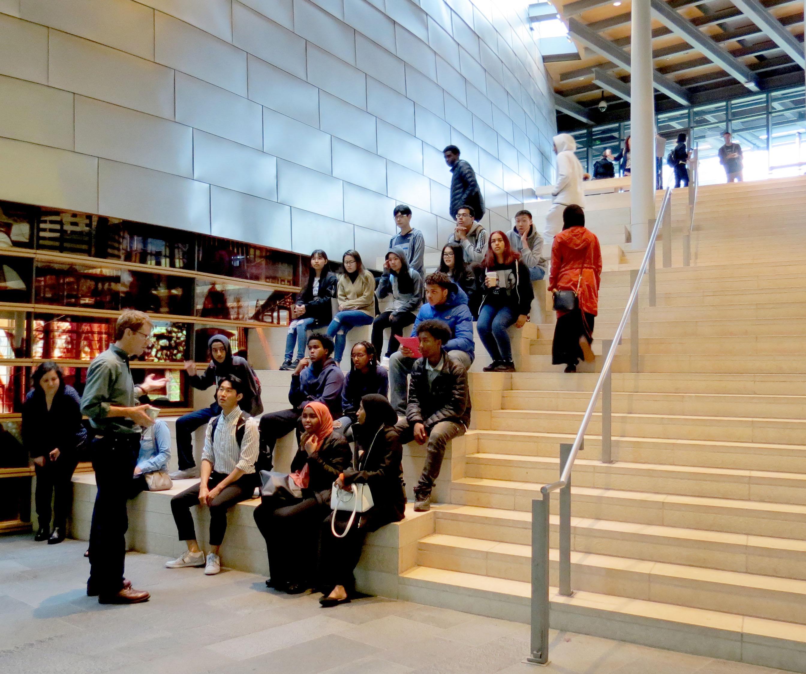 A group of students listen to a Youth Development Counselor