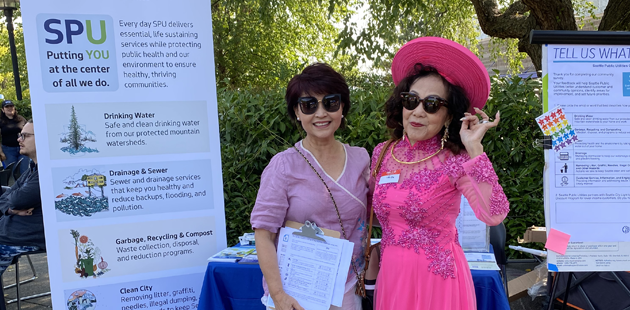 Two community liaisons smiling at an event. One person is dressed in a fancy pink dress