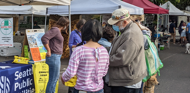City staff talking with people at the farmers market about Seattle Public Utilities