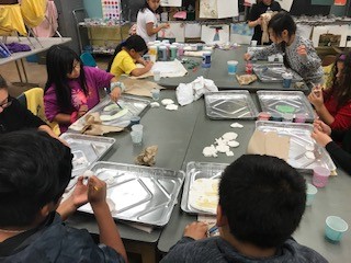 kids sitting around a table doing an art project