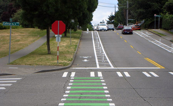 A photo of a bike lane that uses plastic flexposts as the divider