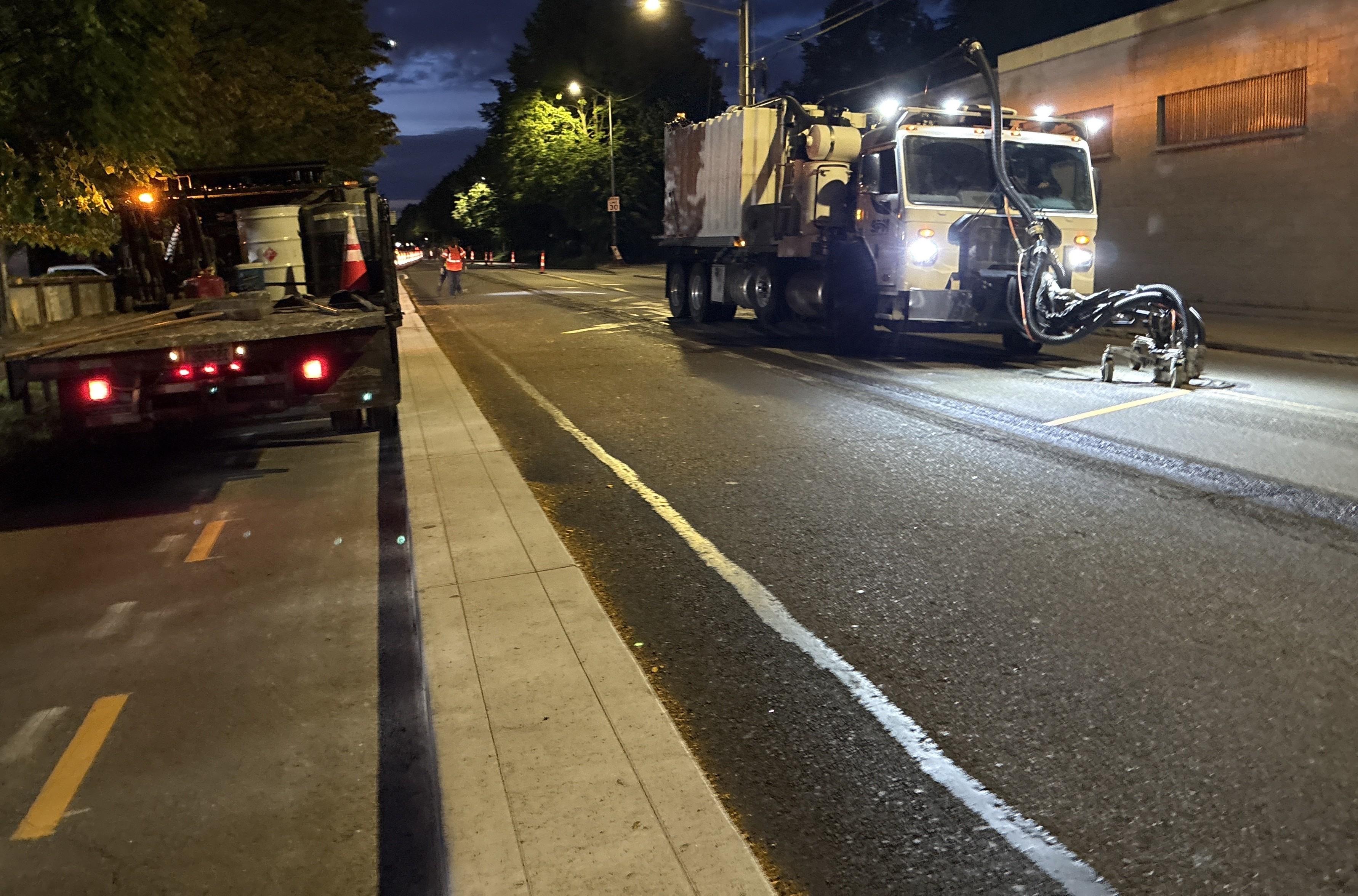Photo showing striping installation on Airport Way S and S Alaska St.