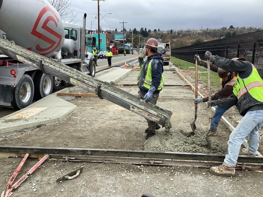 Crews pouring concrete for the new multi-use trail on S Albro Pl