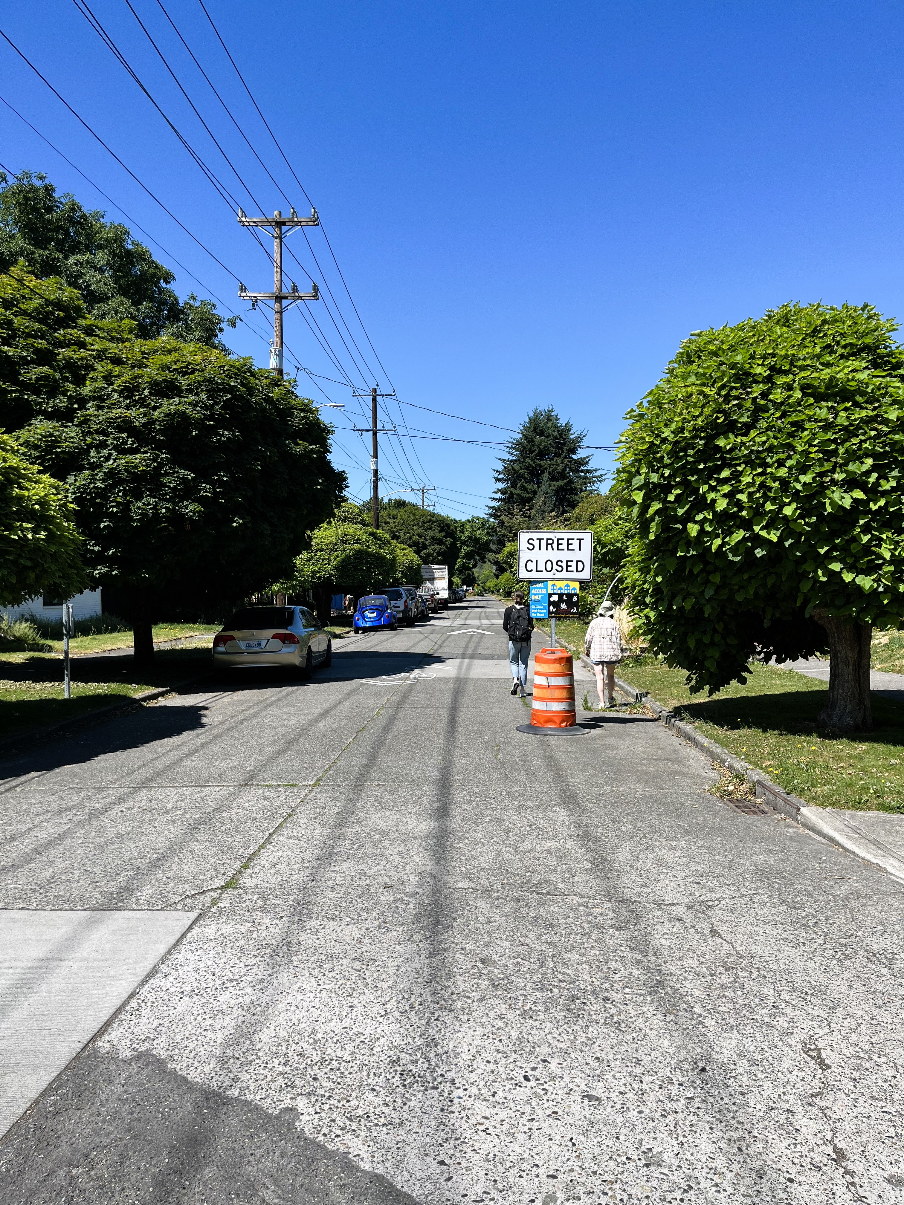 Two people walk past a temporary sign on the South Park Healthy Street