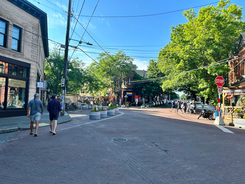 Pedestrians crossing Ballard Ave near a new painted curb bulb