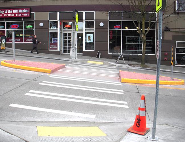 A crosswalk that leads to a pedestrian island in the middle of the street