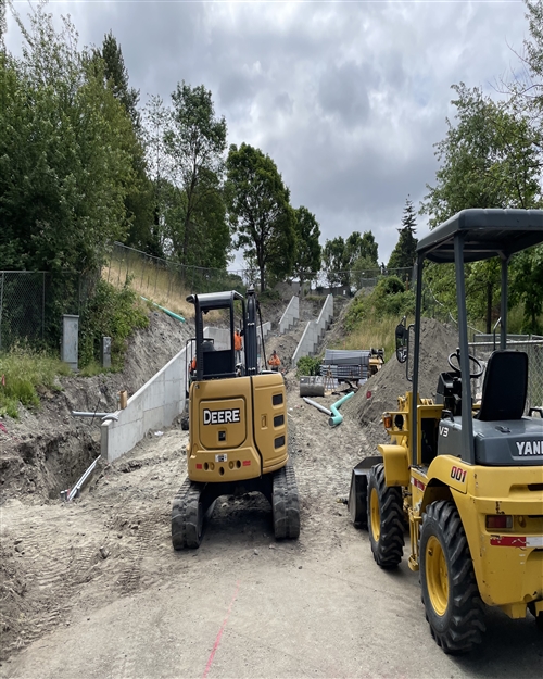 Construction Vehicles parked at the bottom of what will become the Hiawatha Place Staircase. The staircase sides are complete, with concrete forming the structure of each platform/landing