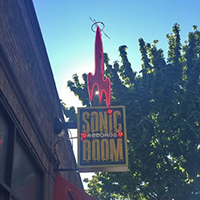 A neon sign featuring a red rocket ship for Sonic Boom Records