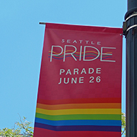 A colorful banner advertising the Seattle Pride Parade date