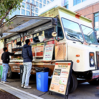 Two people waiting to order from a food truck