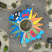 A colorful mural depicting an orca and the Space Needle surrounding a traffic circle