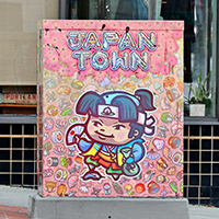 A colorful illustration of the hero Momotaro on a signal box in Japantown