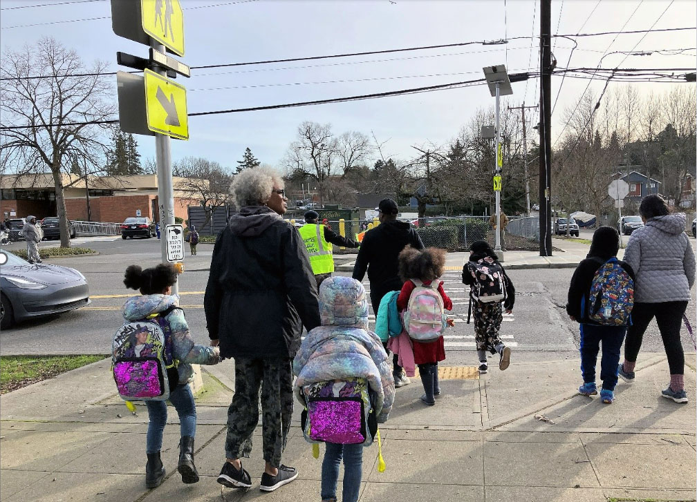 Families cross at the push button flashing beacon (S Henderson St at 50th Ave S) by South Shore PK-8 