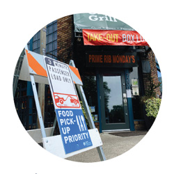 A sign that says three minute passenger load only and Food Pickup Priority in front of a restaurant