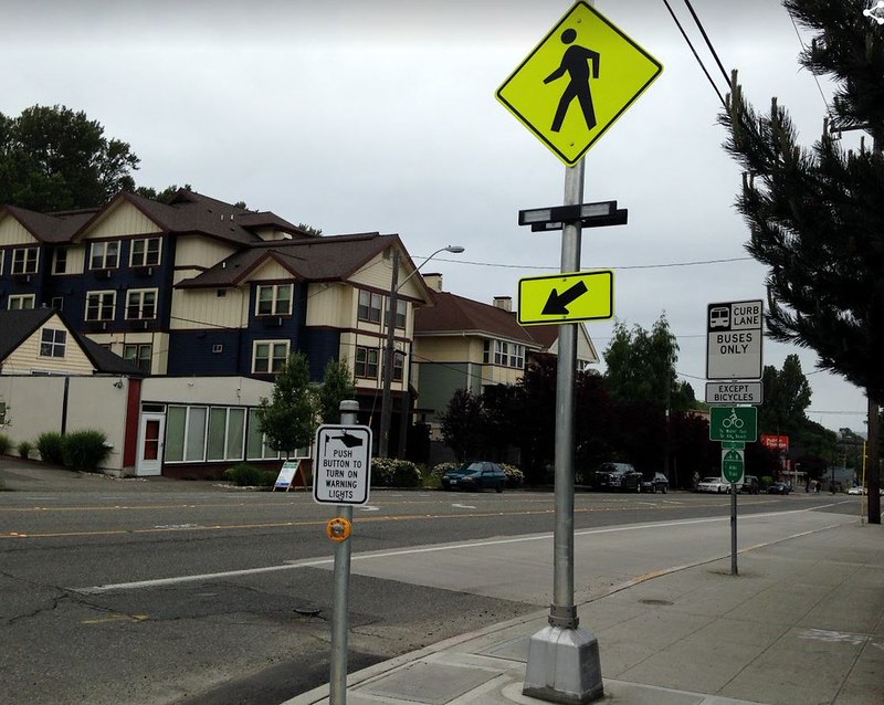 Rapid Flashing beacon at a crosswalk, with large pole and yellow signage
