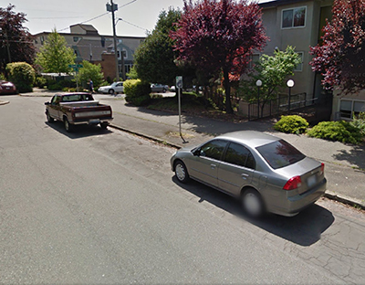 Neighborhood street with cars parked along curb