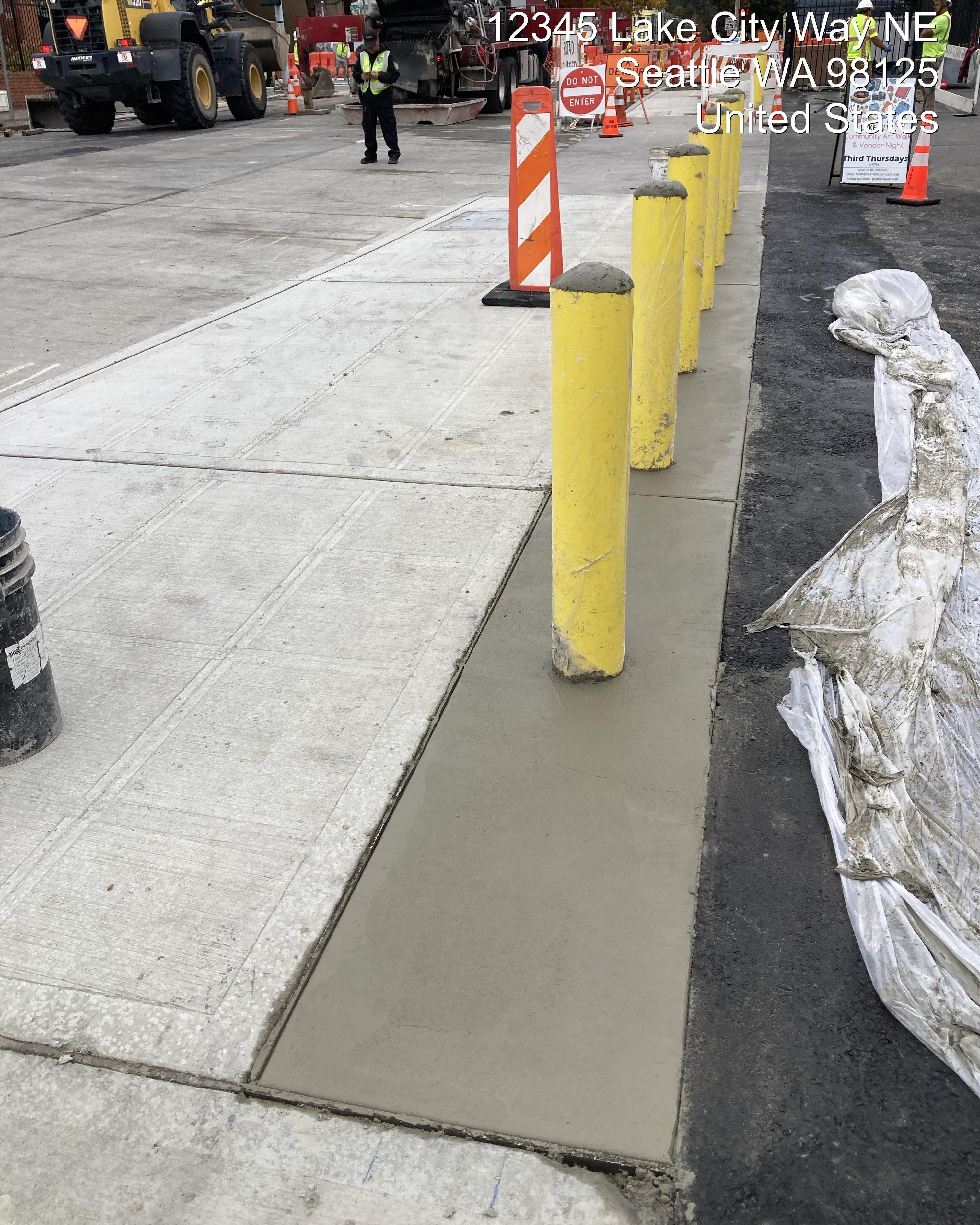 Image showing concrete bollards installed behind new sidewalk adjacent to private parking lot on 30th Ave NE.