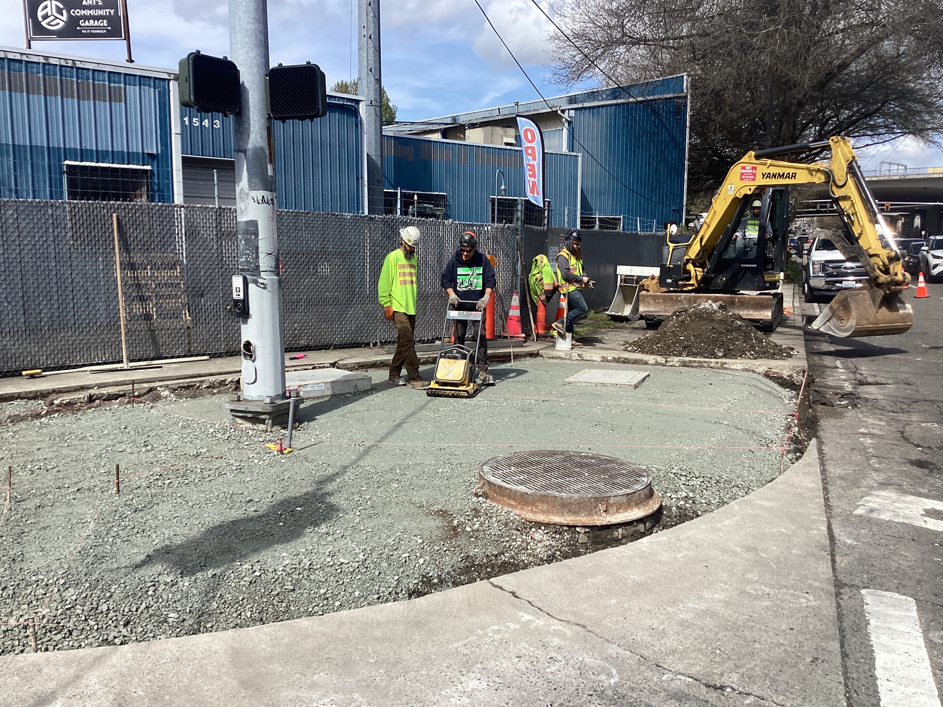 Photo showing crews work to prepare sidewalk corner for concrete pour.