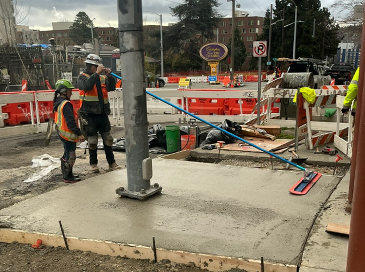 Image shows the pouring of new sidewalks in the University District