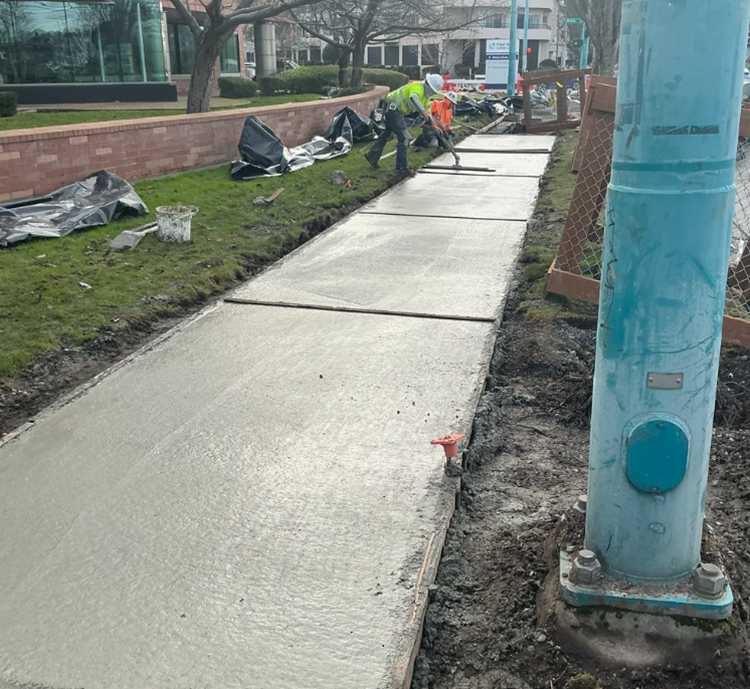 The image shows the team finishing new sidewalks along Fairview Ave N