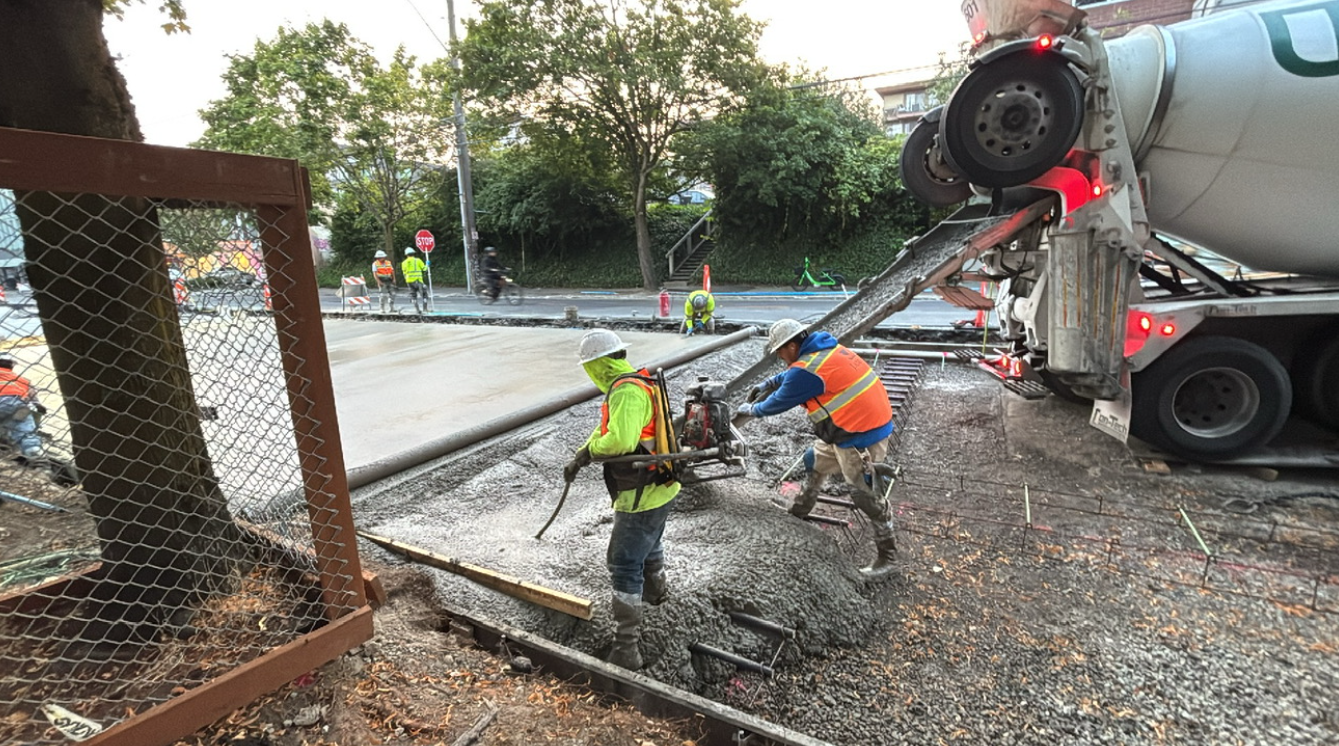 Image shows crews pouring concrete on the west side of Eastlake Ave E and E Louisa St. 