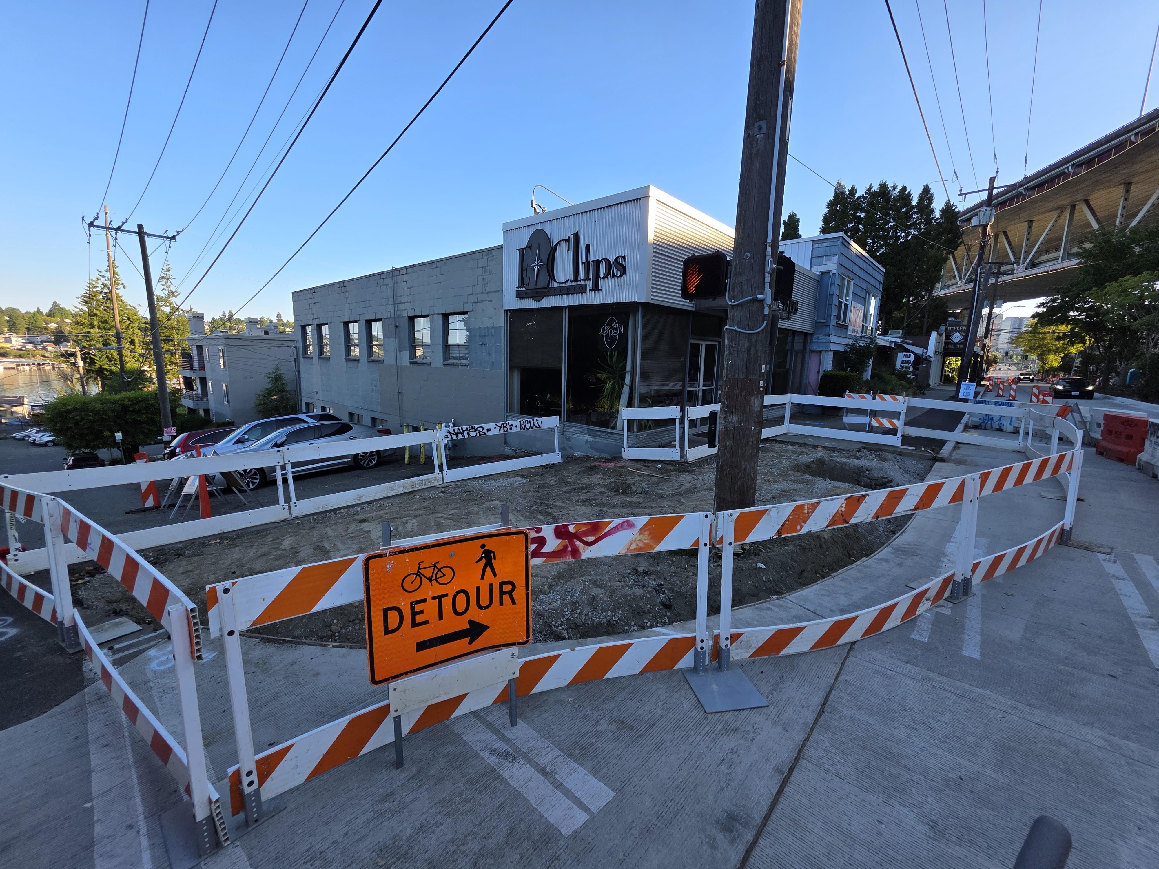 Image shows a detour sign and temporary barriers around a construction area at Eastlake Ave E and E Allison St.