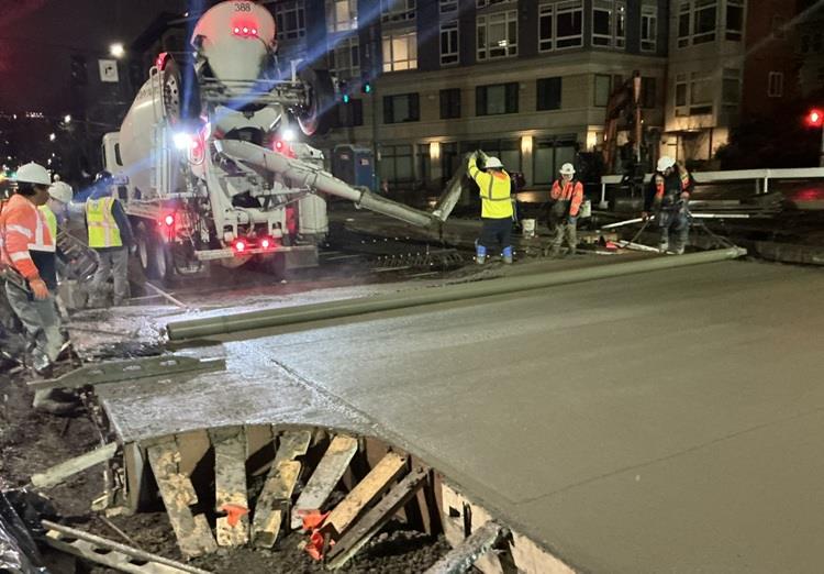 Image shows the pouring of concrete to form the new street surface on Eastlake Ave E