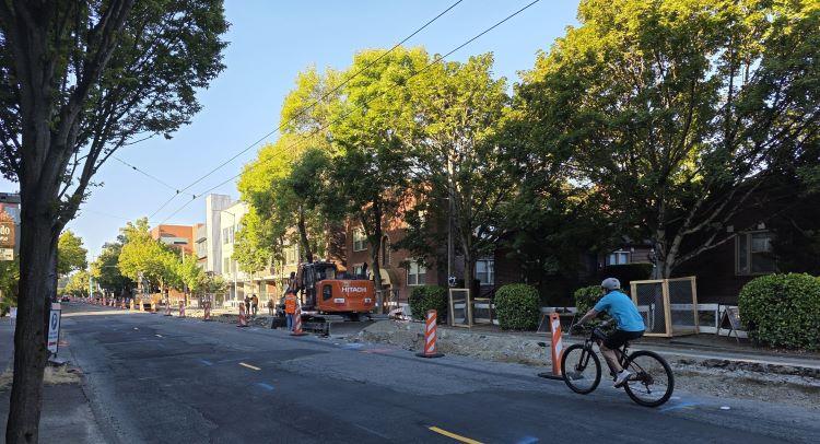 Image shows a people on bikes ride past street demolition on Eastlake Ave E.
