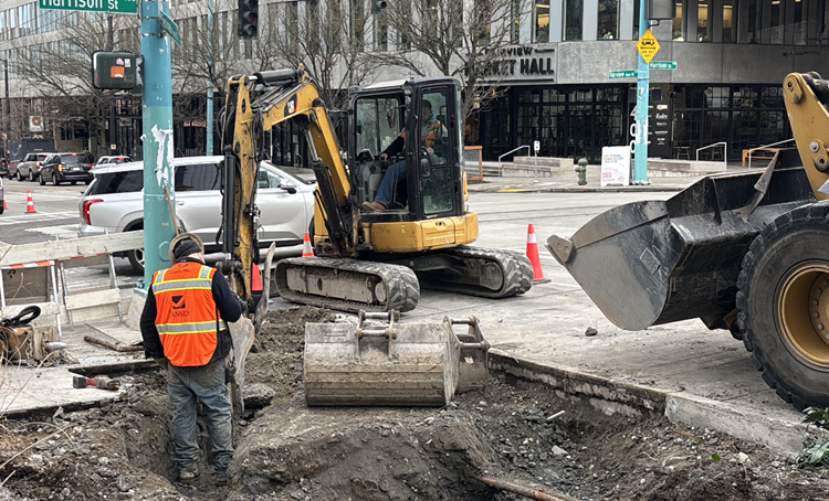 Image shows the team building new concrete pedestrian ramps and installing electrical wires at Fairview Ave N and Harrison St