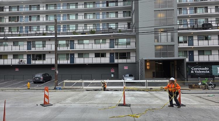 The image shows recently poured concrete panels in front of the driveways at the Coronado and Valencia Apartments