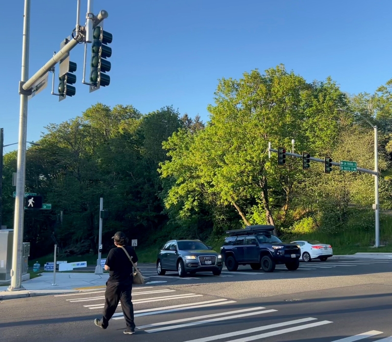 Person walking across Southwest Holden Street on Highland Park Way Southwest under the new traffic signal 