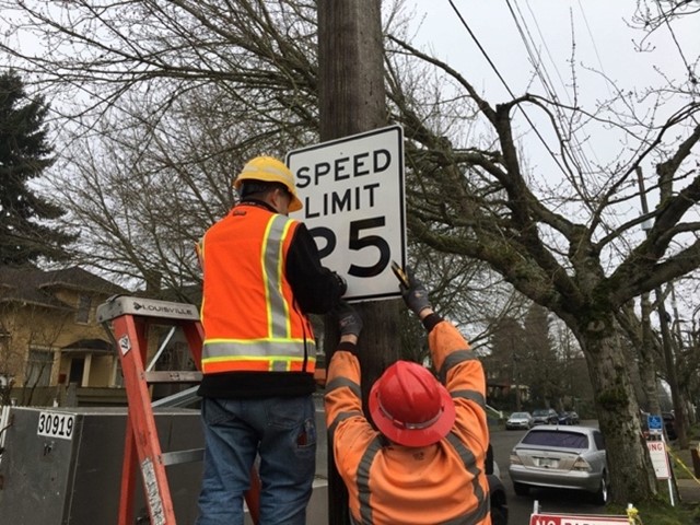 SDOT workers install a new 25 mph speed limit sign