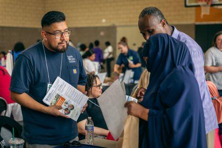 SPU representative speaking with customers at a resource fair.