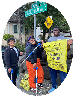 Three Adopt a Street volunteers from the Rainier Beach Action Committee pose with their cleanup tools.