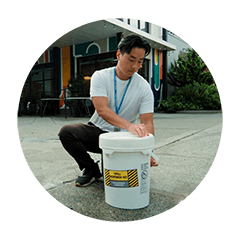 SPU employee with spill response kit in front of a business.