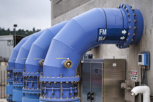 Closeup of large blue pipes arcing up to side of the station.